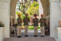 Staff in livery welcoming guests under the painted entrance arch