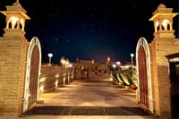 Stone entrance gateway with chhatris under a starry night sky