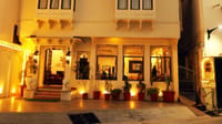 Haveli facade with jharokha balconies lit at night