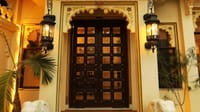 Massive carved wooden door flanked by lanterns