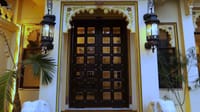 Massive carved wooden door flanked by lanterns