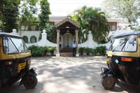 Entrance gate of The Malabar House with auto-rickshaws waiting outside on Parade Road, Fort Cochin
