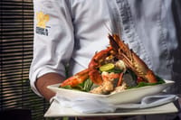 Chef at Malabar Junction, The Malabar House, holding a platter of lobster and prawns