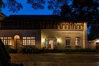 Old Harbour Hotel front elevation lit at night, arched doorway and shuttered windows