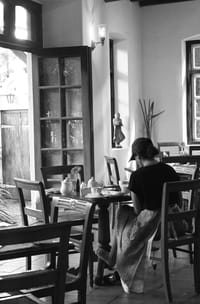 Black and white view of the dining room at Old Harbour Hotel with tall glazed windows