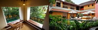 Tea Bungalow, Fort Kochi: a first-floor balcony with cane recliner beside the courtyard swimming pool with loungers and umbrellas