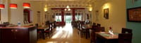Tea Bungalow, Fort Kochi: Cafe du Mahe restaurant with dark wood tables, red pendant lamps and doors open to the garden