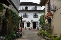 Street entrance of The Old Courtyard Hotel on Princess Street, Fort Kochi, with its tiled roofs and wooden balcony