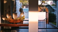 Model of the Dutch ship Batavia in a glass case at the hotel reception, evening light