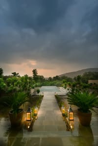 Lantern-lit pool and stone walkway at dusk