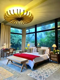 Bed in a glass-walled villa facing trees