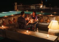 Candlelit sunken dining seating beside the pool