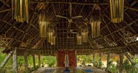 Open yoga shala under a timber and thatch roof