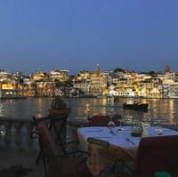 Ambrai terrace tables at dusk facing the city lights