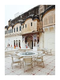 Courtyard tables below a carved facade