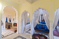 Suite with carved white arches and canopied beds