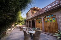 Cane chairs on a terrace by carved doors