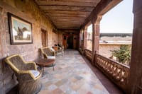Arcaded stone verandah with chairs and table