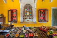Kitchen counter laid out with spices and vegetables below a painted niche