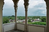 View over the village and treetops from a scalloped arch balcony