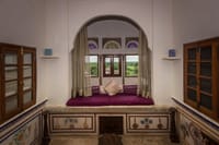 Window seat below a stained glass fanlight, floral panels painted along the base