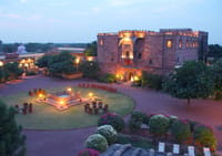 Haveli lit at dusk above its gardens