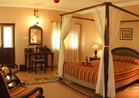 Room with canopied bed and portrait