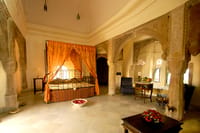 Canopied bed among carved stone columns