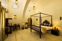 Four-poster bed under a vaulted ceiling