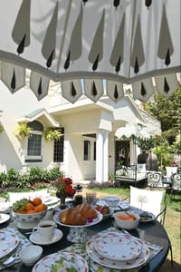 Breakfast table under a canopy outside the house