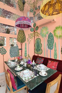 Cafe table set against painted tree walls