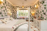 Four-poster bed in a lotus-painted room