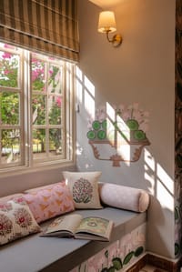 Cushioned window seat below a painted mural
