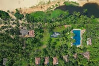 Aerial view of the cottages in the coconut grove between the backwater and the beach