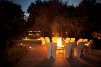 Chairs set round a campfire at night