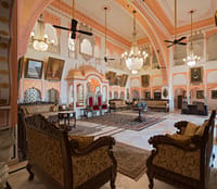 Durbar hall with a painted vaulted ceiling, chandeliers and ancestral portraits