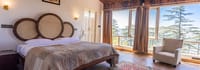 Super Moon master bedroom, round cane bed head and floor-to-ceiling windows onto deodar trees