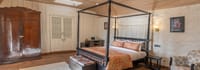 Cosmos room, black spiral four-poster bed against lime-plastered walls