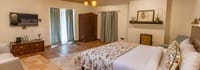 Sunbeam bedroom with floral bedspread, wooden floor and warm lamps
