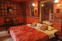 Double bed below a gilt framed mirror