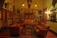 Sitting room with framed portraits and armchairs