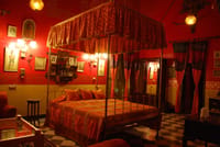 Canopied bed in a red walled room