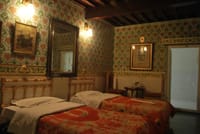 Twin beds in a wallpapered room