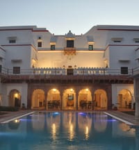 Swimming pool and lit arcade at dusk