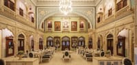Ornate hall laid for dining under chandeliers
