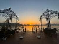 Lakeside terrace with wrought-iron gazebos looking over Lake Pichola at sunset