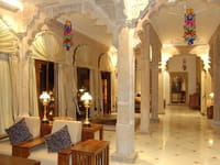 Pillared corridor with lamps and cushioned benches