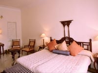Bedroom with four-poster bed and armchairs