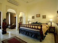 Bedroom with dark wood bed and patterned rug