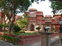 Red sandstone palace facade above the garden